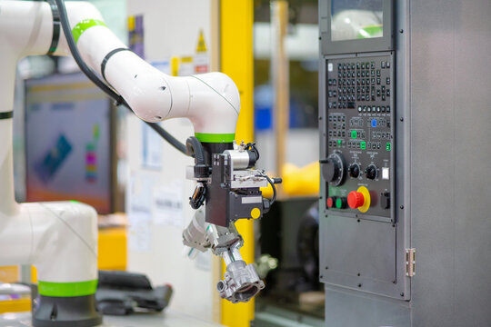 Factory 4.0 concept:  The collaboration of robot and CNC machine, automotive part is taken into CNC milling machine automatically by gripper on cobot