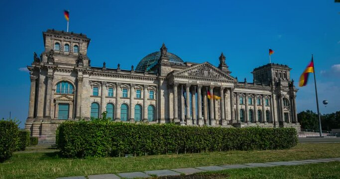 Berlin, Germany - September 16, 2021: Time lapse at the German parliament, Reichstag or Bundestag in the capitol of Germany. German flags waving in front of the building. Imperial Diet in Berlin