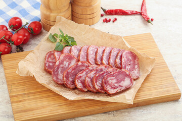 Sliced salami sausages over board