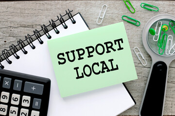 support local. notepad and green sticker on the table. sticker text