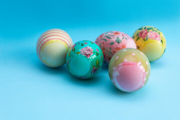 Fototapeta na wymiar Bright multi-colored eggs in film lie on a blue background. Easter card