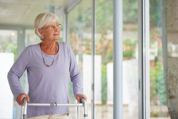 Every reason to be positive. Shot of a senior woman using an orthopedic walker indoors. - obrazy, fototapety, plakaty