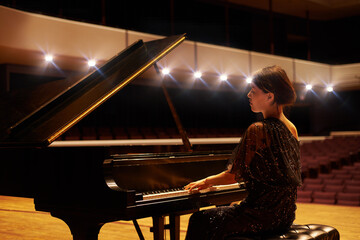 Music is her artform. Shot of a young woman playing the piano during a musical concert. © Alexandra W/peopleimages.com