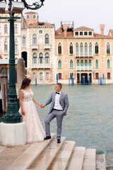 Bride and groom holding hands near Grand Canal