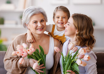 Happy International Women's Day.Smiling  family grandmother, mother and daughter with flowers  ...