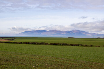 10 March 2022 A view of the Mourne Mountains with their cloud covered peaks. Viewed across Dundrum Bay from the Killough area in County Down Northern Ireland 