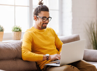 Black male freelancer working at laptop at home