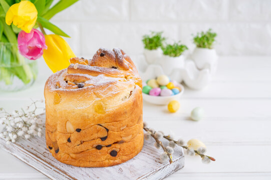 Easter composition. Traditional Ukrainian Easter cake - Cruffin, Kraffin or Kulich with chocolate and candied fruits on a white wooden background. Paska Easter Bread. Copy space