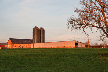 A red brick farmhouse with metal silos in the Burgundy countryside in France © sissoupitch