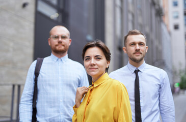 Strong confident professional group standing outside. Caucasian team of young male and female business executives. Finance, real estate or construction industries concept. High quality image