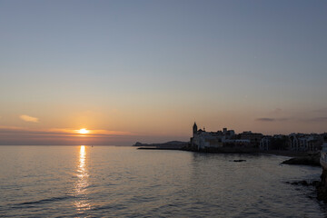 Obraz premium Picturesque sea evening landscape. Sunset over the mediterranean sea. Evening city, sea and sunset. The sun is above the horizon line.