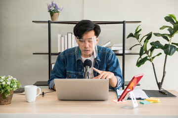 Young Asian blogger recording live streaming video on his blog