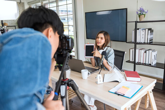 Videographer recording live streaming of young female blogger
