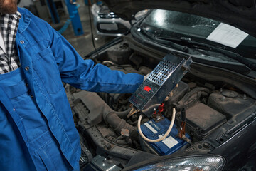 Man holding load plug for checking the battery