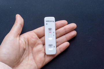 Hand holding the SARS CoV-2 virus rapid test kit with negative results. Antigen covid test