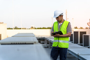 Factory engineers walking and checking the cooling system of the factory. Fore man records the...