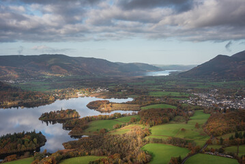 Naklejka premium Beautiful landscape Autumn image of view from Walla Crag in Lake District, over Derwentwater looking towards Catbells and distant mountains with stunning Fall colors and light