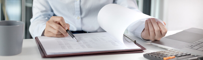 Asian businesswoman sitting and analyzing company financial data, Using laptops and data graphs to work, Online communication , Tax, Vat, Work for home, Social distancing, Work on the internet.