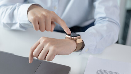 Businesswoman uses a smartwatch to make reminders or keep a small note of important messages on her wristwatch. Use of technology in work, Reminder Assistant,Watch time, Touch screen.