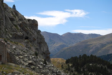 imagen de una pared de montaña con un valle enorme y el cielo azul 