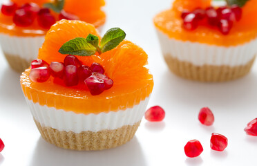 dessert. cake with tangerine slices and pomegranate seeds on a light background