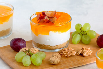 dessert in a glass cup with nuts and fruits on a wooden board. healthy eating