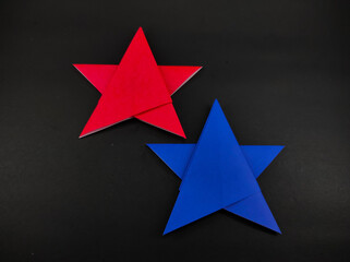 Abstract Defocused Two-colored star made of origami paper isolated on black background