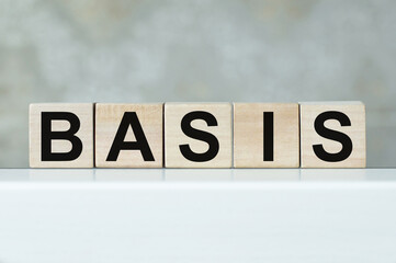 Wooden cubes with letters on the table in the office. Text BASIS. Financial and business concept.