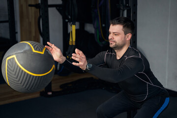 Fototapeta na wymiar Man doing exercise with fitness ball in gym