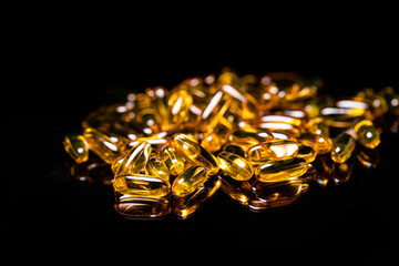 Close up of Omega 3 gel capsule on a reflective black background