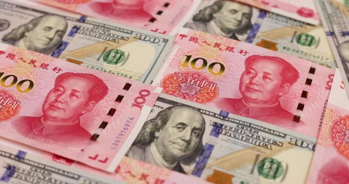 rotation of China yuan or renminbi rmb against US dollar bill of 100 banknotes. Chinese and USA trade war.