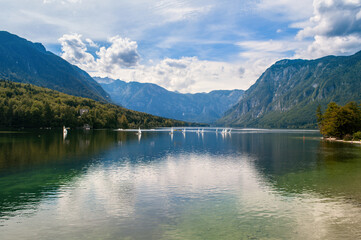 Lake Bohinj in Slovenia. Beautiful nature, big lake and high mountains around. Summer weather for swimming and recreation by the water.