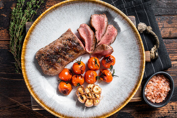 Roasted Lamb tenderloin meat in plate with grilled tomato and garlic, mutton sirloin fillet steak....