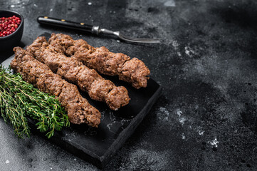 Grilled Shish kebab on a stick, from ground beef and lamb meat, turkish adana kebab. Black...