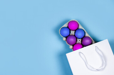 Banner on a blue background. The concept of online shopping for Easter, purchases and sale for the holiday. Gift bag with Easter eggs