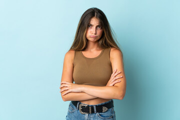 Young caucasian woman isolated on blue background feeling upset