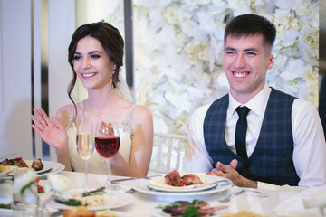 Emotional beautiful newlywed couple smiling at wedding reception