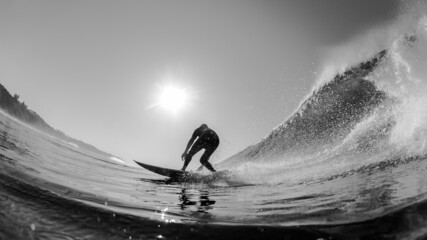 Surfer Surfing Ride Ocean Wave Bottom Turn Rear Water Photo Action Close-up Silhouette in Black and White.