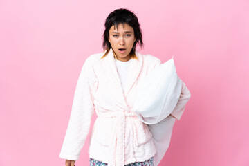 Young Uruguayan woman in pajamas over isolated pink background