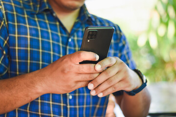 man using mobile phone in coffee shop