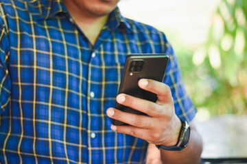 man using mobile phone in coffee shop