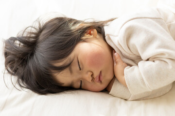 Obraz na płótnie Canvas 布団で昼寝している赤ちゃん（1歳8か月、日本人、女の子）