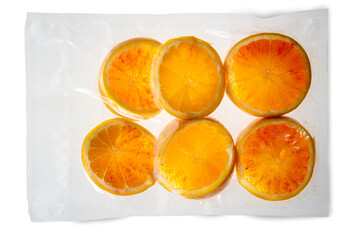 Slices of oranges fruit in vacuum packed sealed for sous vide cooking isolated on white background...