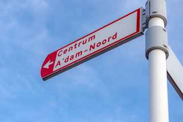 Selective focus of guide sign board in city center under blue sky as background, Directional post to Centrum (Centre) A'dam-Noord (Amsterdam North) Netherlands.