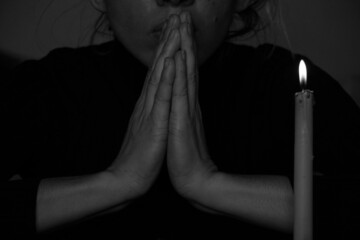 A young Ukrainian girl prays near a candle for Ukraine in Ukraine, a girl poured candles in the dark close up