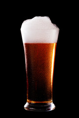 Glass of beer with foam on black background.t