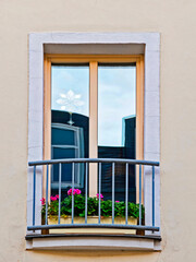 french style balcony window with violet colored geranium flower pots, house facade detail, Saxony, Germany