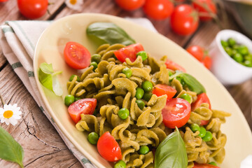 Fusilli pasta with cherry tomatoes and peas.
