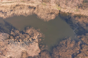 Jezioro w słoneczny, wiosenny dzień widziane z dużej wysokości. Zdjęcie zrobione z użyciem latającego drona. - 492362183
