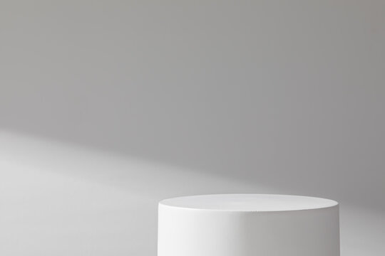 White cylindrical stone podium on a background of concrete wall © Mr. Music